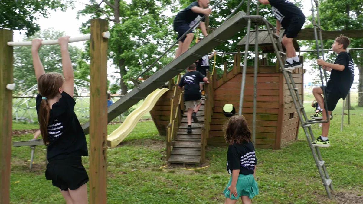 Kids’ Bible Camp campers climbing and playing on the playground